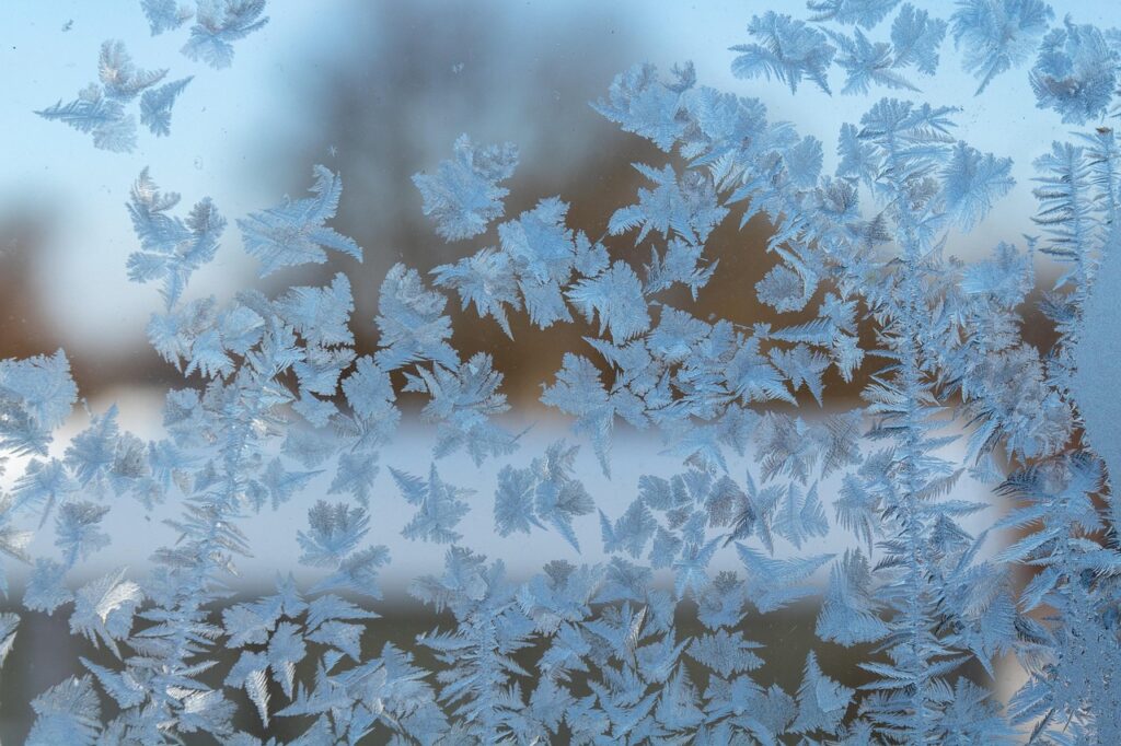 window covered in snowflakes needs winter insulation